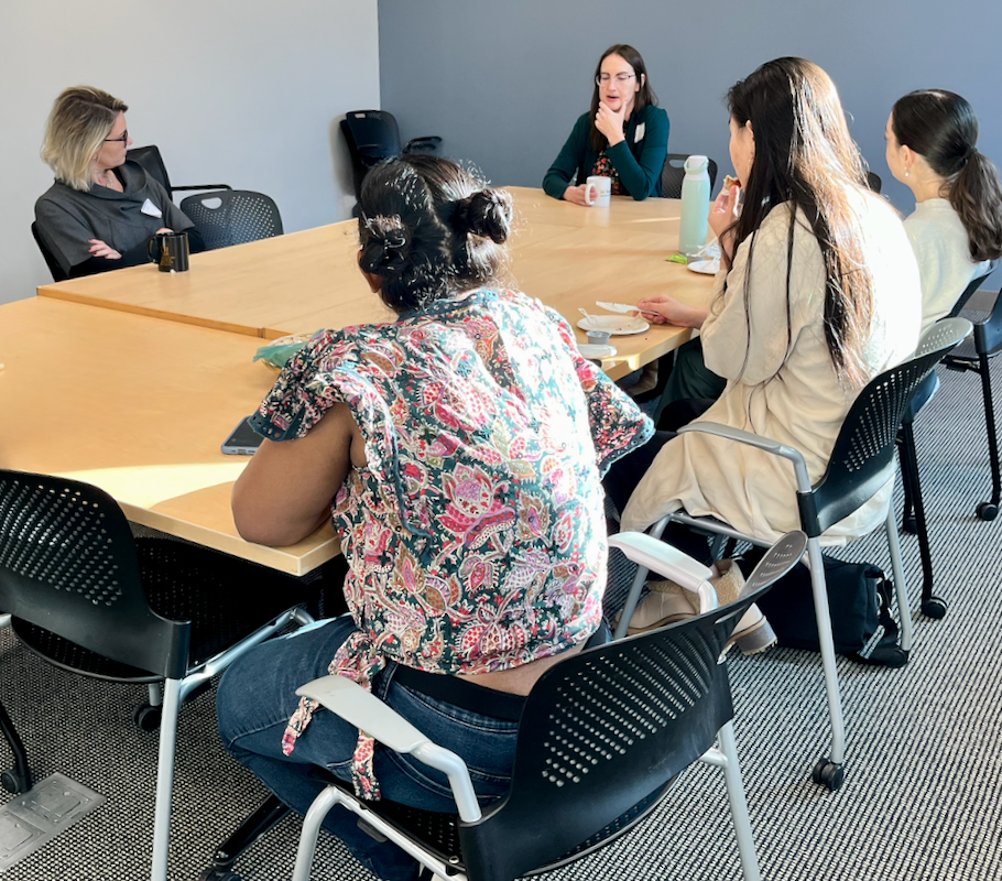 Attendees sit in discussion at a WISE & Shine event featuring a University of Michigan alumna.