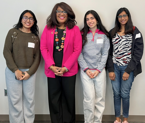 Three students stand with Dr. Lou Edje at a WISE & Shine event.