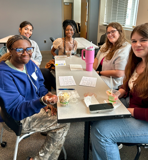 Five WISE students sit around a table at an ice cream social.